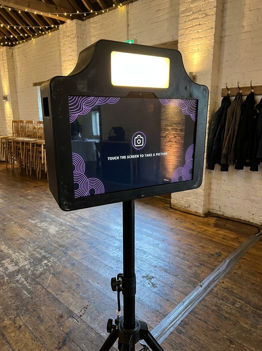 De zwarte photobooth opgezet op zijn statief in een feestzaal